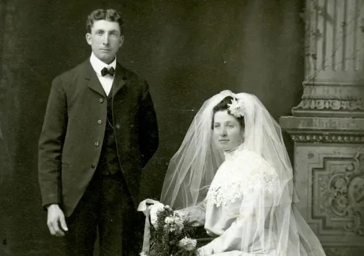 Black-and-white historical wedding photo of a bride and groom